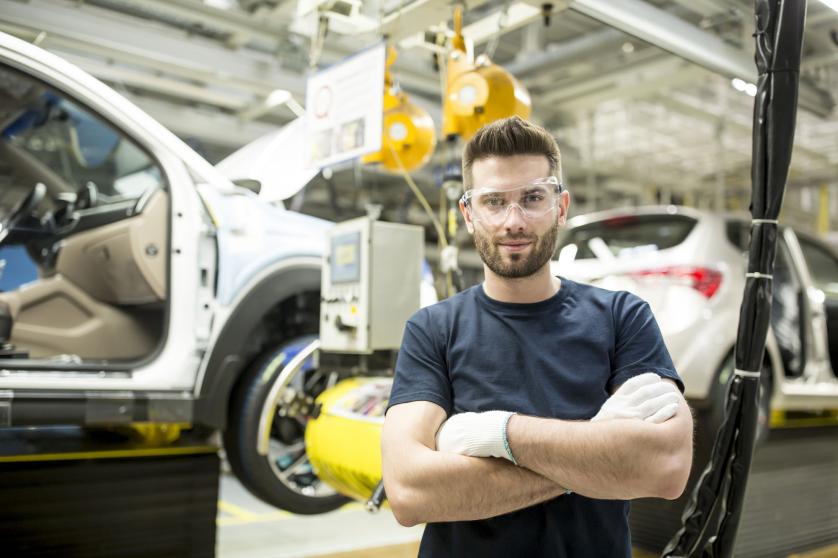 Ritratto di operaio sicuro di sé in una moderna fabbrica di automobili