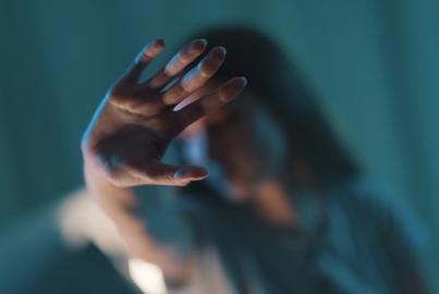 Woman reaching her hand out in attempt to protect herself